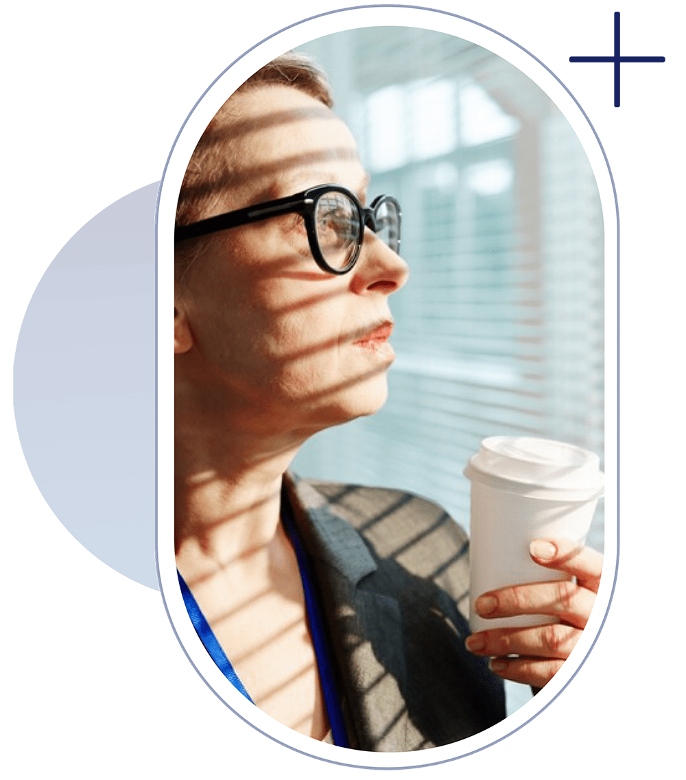 a young lady is thinking about Vision while having a cup of cofee in her hands