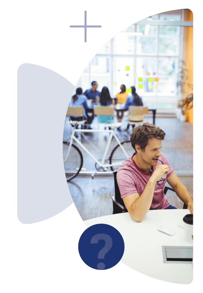 Young man is sitting besides a table and thinking while software development process